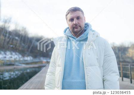 Happy bearded young man standing and smiling in wintertime outdoors Happy bearded young man standing and smiling in wintertime outdoors 123036455