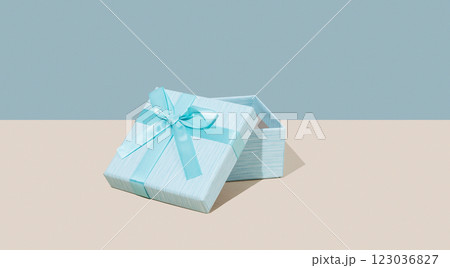Open blue gift box on beige background. Concept of advertising blank mockup or banner for holiday Open blue gift box on beige background. Concept of advertising blank mockup or banner for holiday 123036827