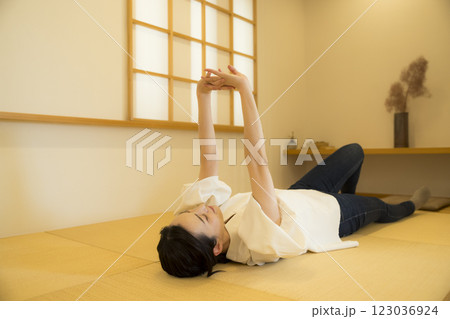 畳の上で寝転がる若い女性 123036924