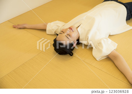 畳の上で寝転がる若い女性 123036928