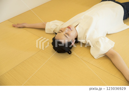 畳の上で寝転がる若い女性 123036929
