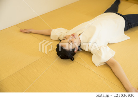 畳の上で寝転がる若い女性 123036930
