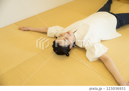 畳の上で寝転がる若い女性 123036931