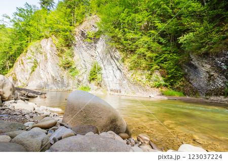 mountain river with stones on the shore. outdoor adventure. scenic landscape with forest on the rocky mountain slope. nature scenery on a sunny summer day. vacation season 123037224