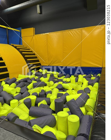Foam cylinder jumping pit. Funny kids playing zone with soft covered blocks 123038215