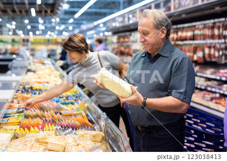 Elderly man choose cheese in supermarket 123038413