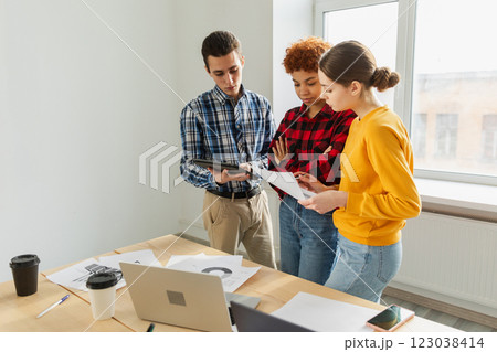 Teamwork brainstorm young professional team concept. Happy multiracial coworkers cooperating working together at office meeting. Diverse colleagues discussing project ideas editing documentation 123038414