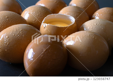 View of Egg yolk in Broken raw chicken eggshell in the among of Fresh chicken egg (Hen egg) on dark background. 123038747