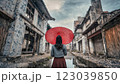古風なヨーロッパの建物の中雨の中、赤い傘をさす女性 123039850