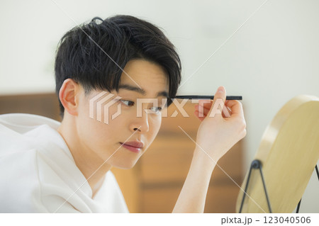 リビングで鏡を見る若い男性 リビングで鏡を見る若い男性 123040506