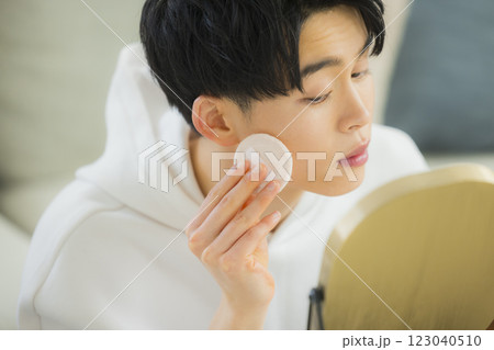 リビングで鏡を見る若い男性 リビングで鏡を見る若い男性 123040510