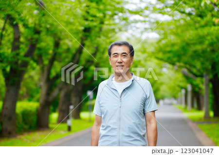 公園の緑の中に立つ笑顔のシニアの男性 公園の緑の中に立つ笑顔のシニアの男性 123041047
