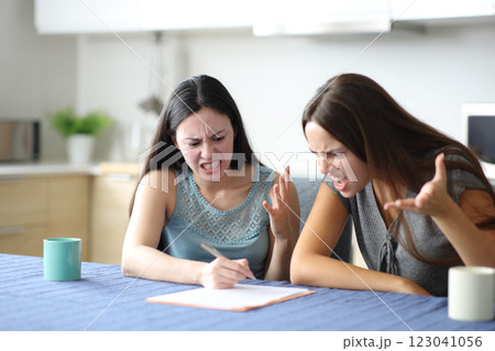 Angry roommates reading paper contract 123041056
