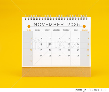 November 2025 desk calendar on yellow color background. 123041190