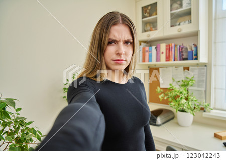 Close-up selfie portrait of teenage confused female looking at web camera Close-up selfie portrait of teenage confused female looking at web camera 123042243
