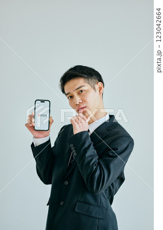 スマホを持つ20代の若い男性　新NISA 123042664