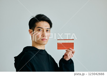 預金通帳を持つ20代の若い男性 123042666