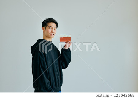 預金通帳を持つ20代の若い男性 123042669