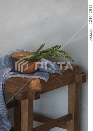Fresh asparagus on rattan stool with linen tea towel 123042913