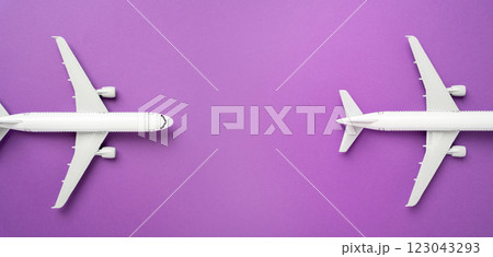 Two airplanes on a lilac background and space for text. Passenger flights. Air travel, aviation industry, airline services. 123043293