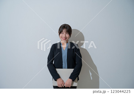 白背景でパソコンを持って微笑む日本人女性 白背景でパソコンを持って微笑む日本人女性 123044225