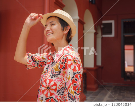 woman in dress and hat exploring vibrant streets of Malacca, Malaysia. 123045034