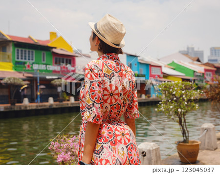 woman in dress and hat exploring vibrant streets of Malacca, Malaysia. 123045037