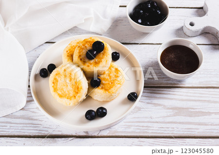 Homemade cottage cheese pancakes and blueberries on a plate on the table Homemade cottage cheese pancakes and blueberries on a plate on the table 123045580