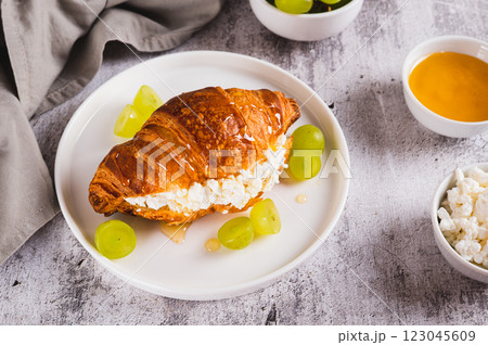 Croissant with ricotta, grapes and honey on a plate on a table Croissant with ricotta, grapes and honey on a plate on a table 123045609