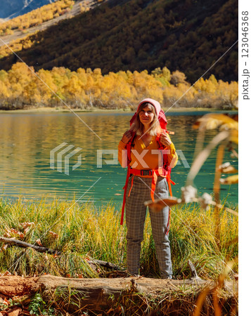 Cheerful hiker woman nearly lake in autumnal mountains. Cheerful hiker woman nearly lake in autumnal mountains. 123046368