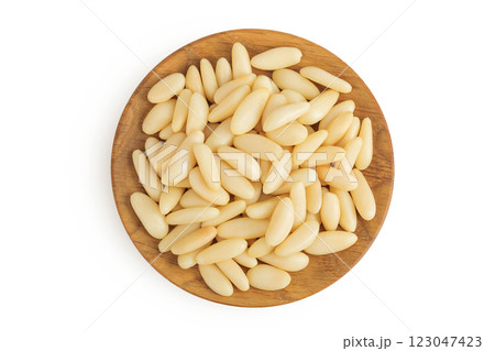 Shelled European pine nuts in wooden bowl isolated on white background with full depth of field. Top view. Flat lay 123047423