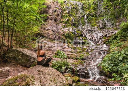Woman Tourist Sitting by Waterfall in Mountain Forest 123047728