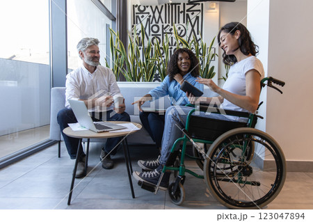 Diverse group of professionals including woman in wheelchair, brainstorming ideas for business Diverse group of professionals including woman in wheelchair, brainstorming ideas for business 123047894