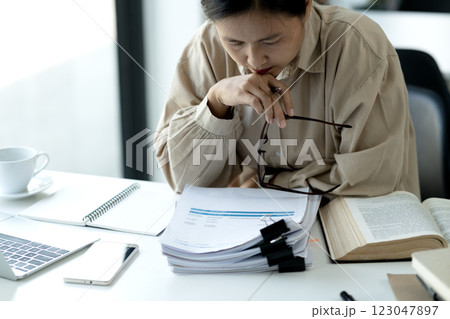 Elder businesswoman in casual attire is thinking while sitting 123047897
