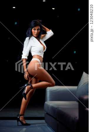 Sexy asian girl in white bikinin and jacket posing near to sofa Sexy asian girl in white bikinin and jacket posing near to sofa 123048210