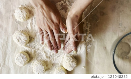 Female hands sculpting cottage cheese pancakes on cuisine table. Arms of young woman preparing tasty breakfast on desk. Process of making cheesecakes in home kitchen. Cooking healthy food concept 123048283