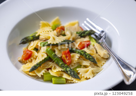 Farfalle pasta with green asparagus, cherry tomatoes and chicken 123049258