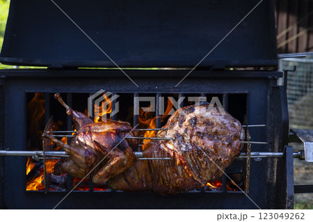 Roasting pork and turkey on spit Roasting pork and turkey on spit 123049262