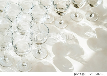Empty crystal wine glasses casting shadows on white tablecloth Empty crystal wine glasses casting shadows on white tablecloth 123050760