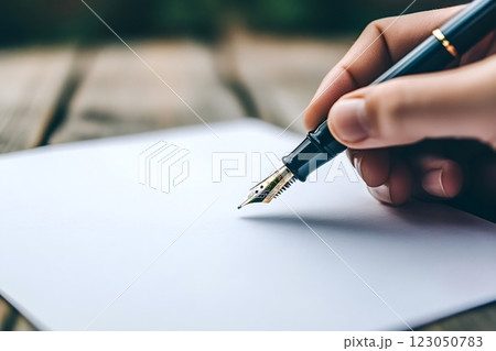 Writer using fountain pen on blank paper on wooden table 123050783