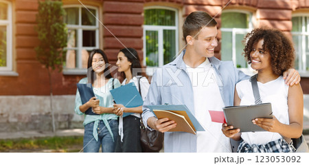 College Romance. Portrait of smiling male student cuddling his african american girlfriend outdoors during break in classes College Romance. Portrait of smiling male student cuddling his african american girlfriend outdoors during break in classes 123053092
