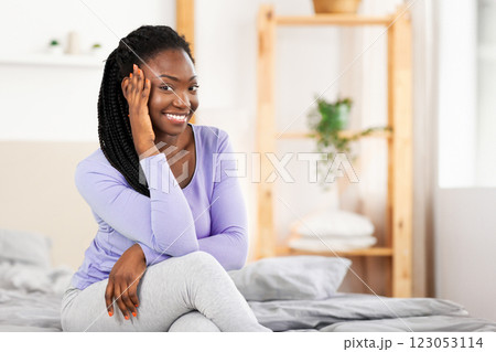 Weekend Morning. Joyful Black Woman Posing Smiling At Camera Sitting In Comfortable Bed Indoor. Weekend Morning. Joyful Black Woman Posing Smiling At Camera Sitting In Comfortable Bed Indoor. 123053114