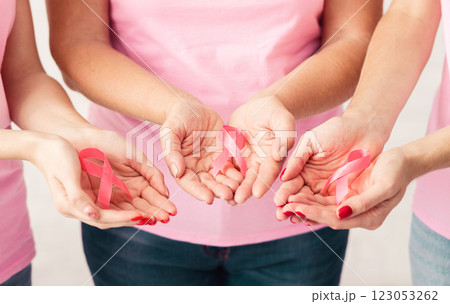 Unrecognizable Breast Cancer Volunteers Women Holding Pink Ribbons Standing Over White Background. Selective Focus, Cropped Unrecognizable Breast Cancer Volunteers Women Holding Pink Ribbons Standing Over White Background. Selective Focus, Cropped 123053262
