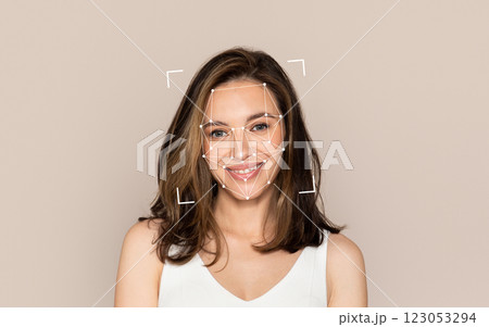 A young woman smiles while a facial recognition overlay appears around her face. 123053294