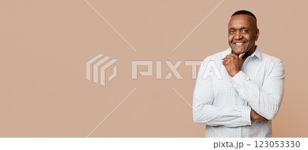 Positive mature african man touching his chin, orange background Positive mature african man touching his chin, orange background 123053330