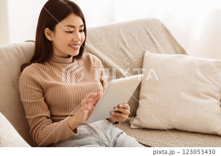 Teen Girl Watching Media Content on Tablet, Sitting on Sofa at Home, Copy Space Teen Girl Watching Media Content on Tablet, Sitting on Sofa at Home, Copy Space 123053430