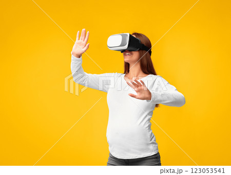 Excited Pregnant Woman Using Virtual Reality Headset Playing Videogame Standing Over Pink Background. Studio Shot 123053541