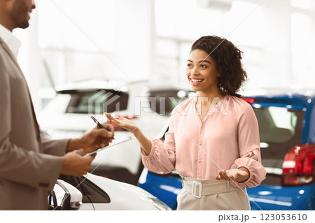Car Buyer. Cheerful Lady Customer Talking With Auto Seller Guy Standing In Automobile Dealership Shop. Selective Focus 123053610