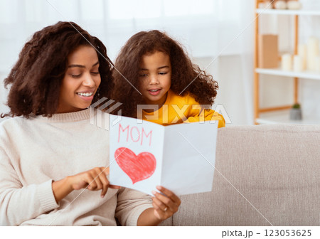 Little Daughter Congratulating Mom On Mother's Day Giving Her Greeting Card Sitting Together On Sofa At Home. Free Space 123053625