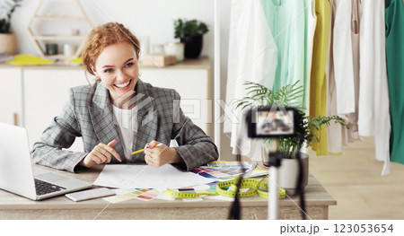 Fashion entrepreneurship. Happy tailor recording video for her blog, working in atelier 123053654